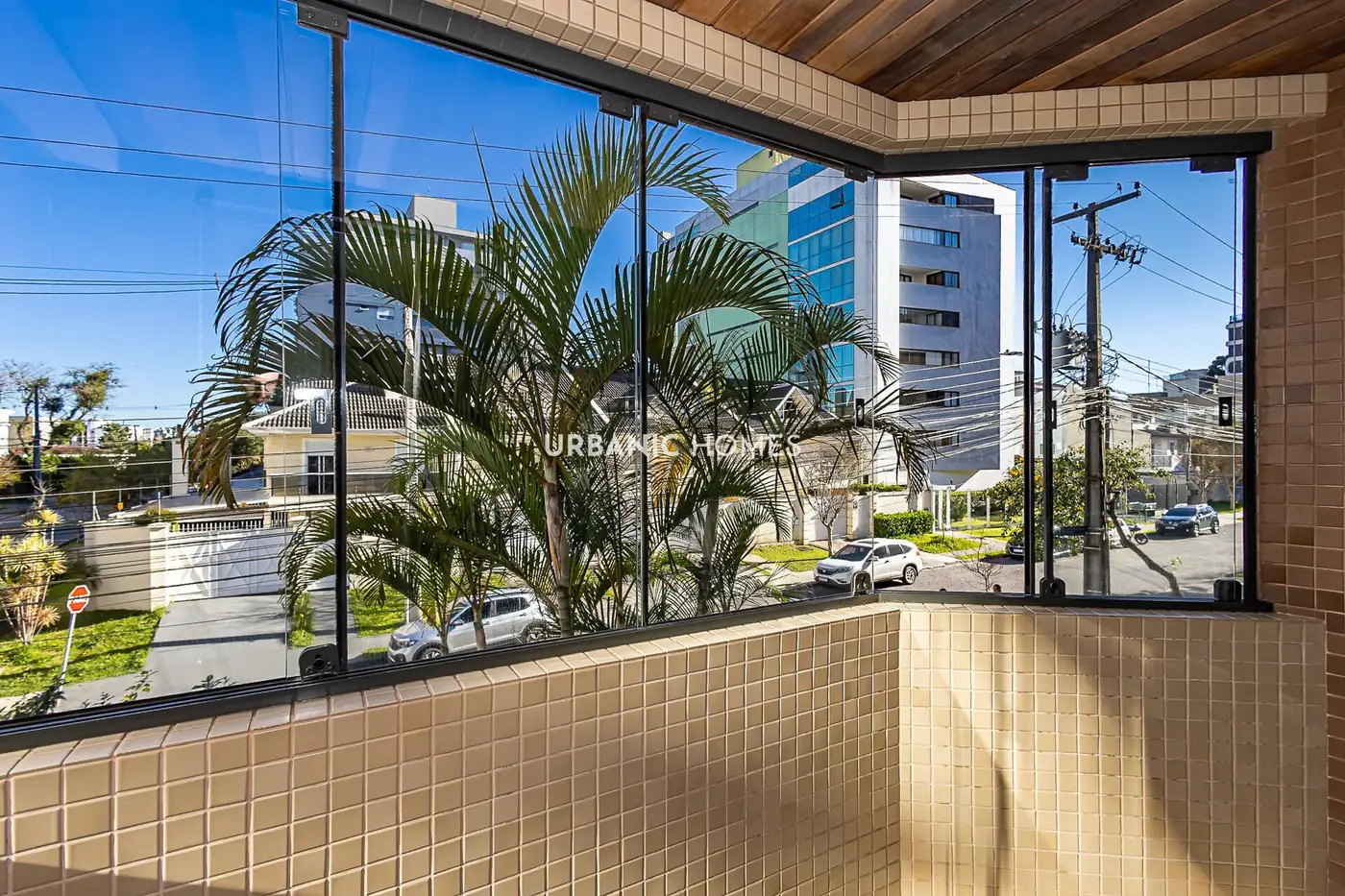 Sacada envidracada com vista para a rua arborizada