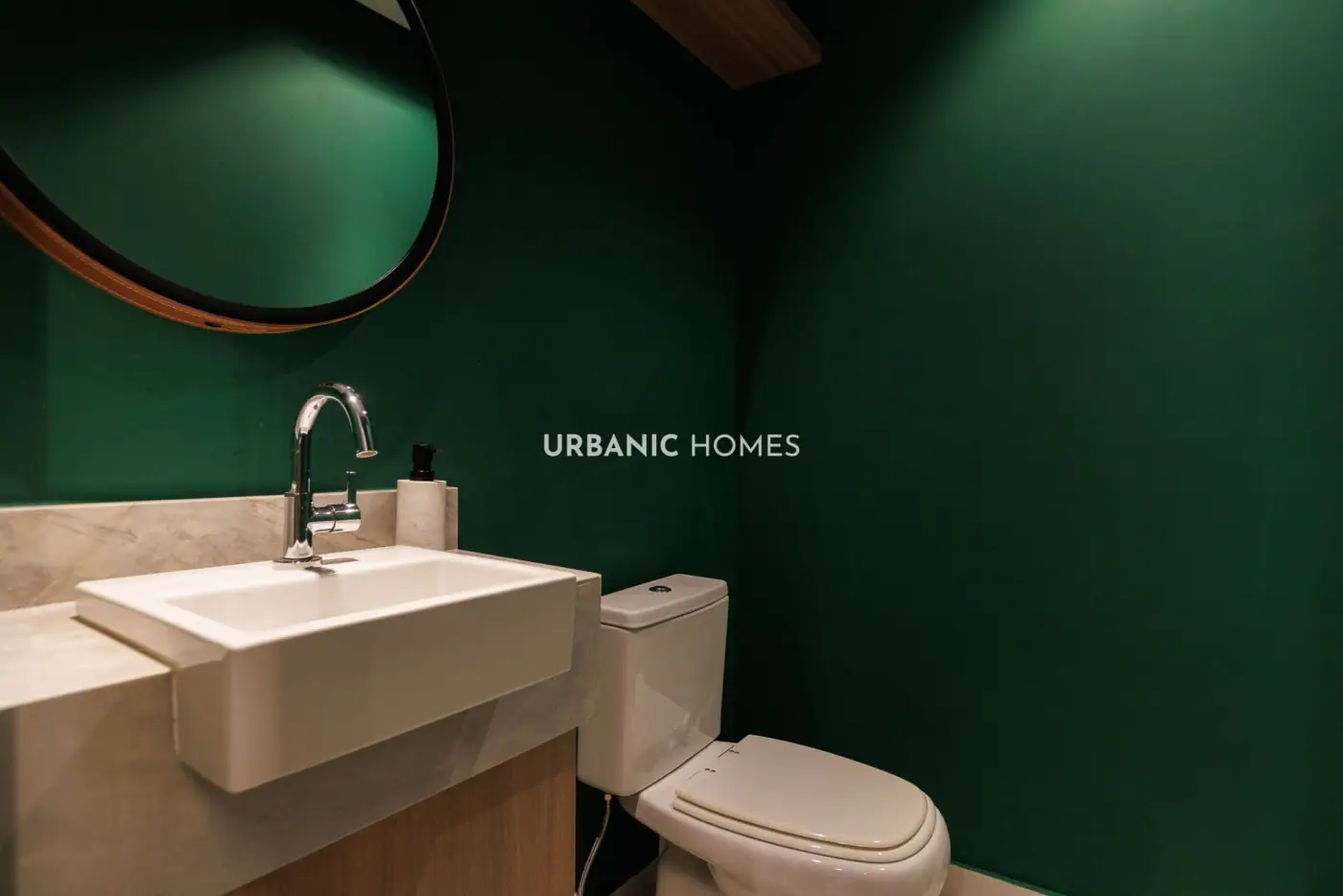 Lavabo com parede verde e espelho redondo