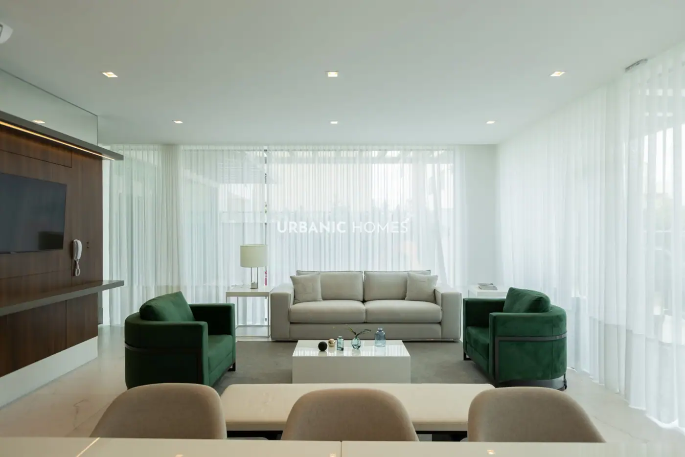Lounge com poltronas verdes e TV